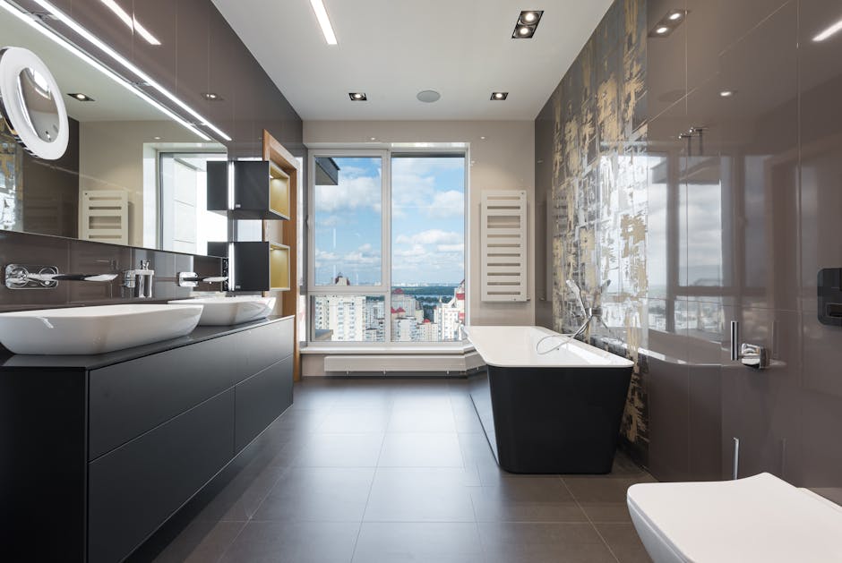 Wooden furniture with bathtub and ceramic sinks and toilet bowl in contemporary master bathroom with big windows in daylight