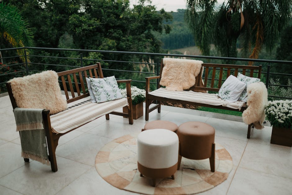 Beautiful outdoor patio setup with wooden benches, cushions, and garden view, perfect for relaxation.